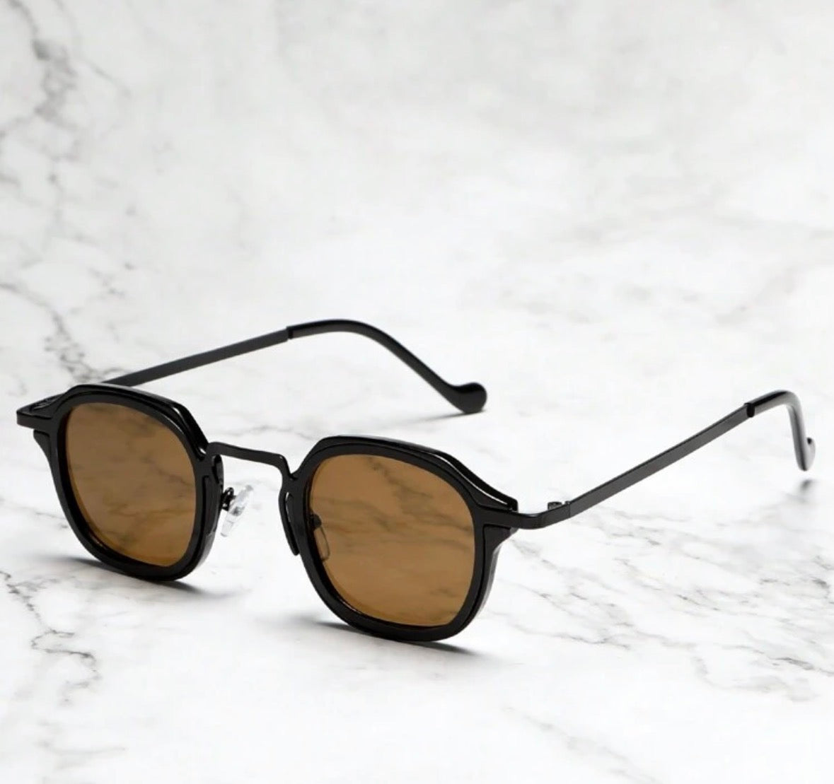Oculus Classic sunglasses with amber polarized lenses resting on white marble